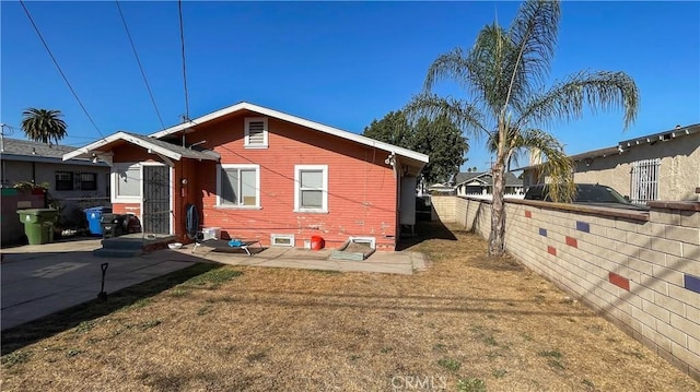 rear view of property featuring a lawn and a patio