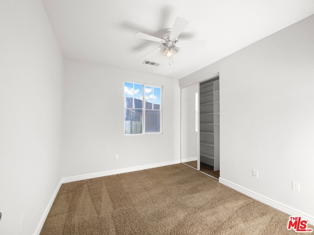 carpeted spare room with ceiling fan