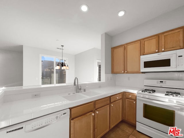 kitchen with tile countertops, white appliances, sink, tile patterned flooring, and a chandelier