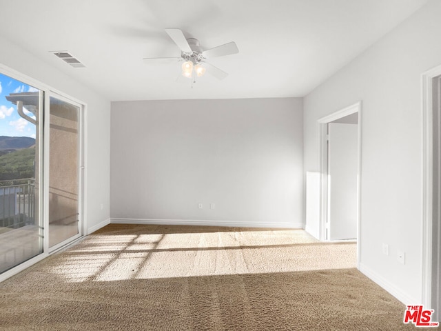 carpeted spare room with ceiling fan