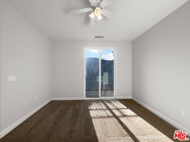 spare room with ceiling fan and dark carpet