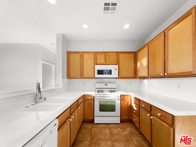 kitchen with backsplash, white appliances, sink, and light tile patterned floors