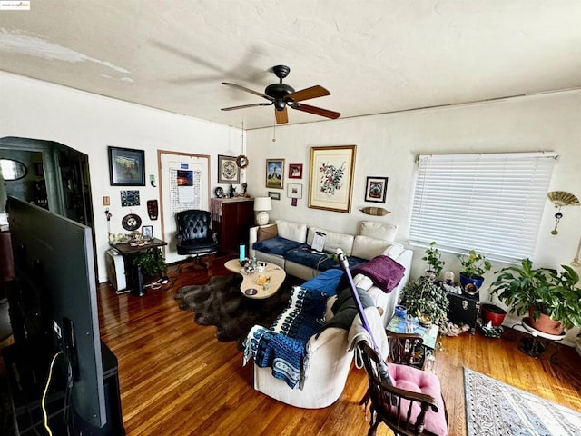 living room featuring ceiling fan and dark wood-type flooring