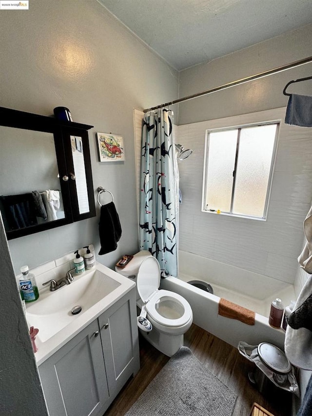 full bathroom featuring toilet, wood-type flooring, vanity, and shower / tub combo with curtain