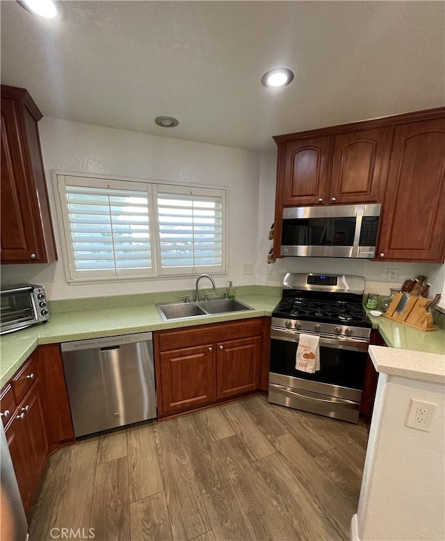 kitchen featuring sink, light wood-type flooring, and appliances with stainless steel finishes