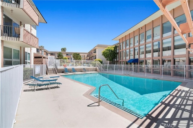 community pool with fence and a patio