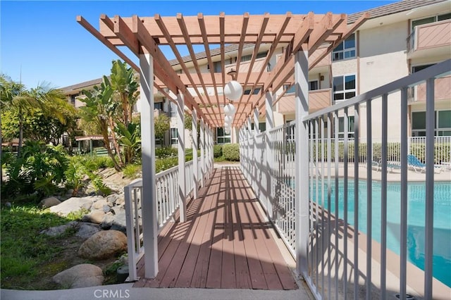 view of community with a swimming pool, fence, and a pergola