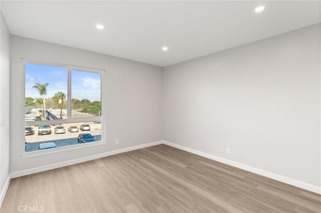 empty room featuring baseboards, wood finished floors, and recessed lighting