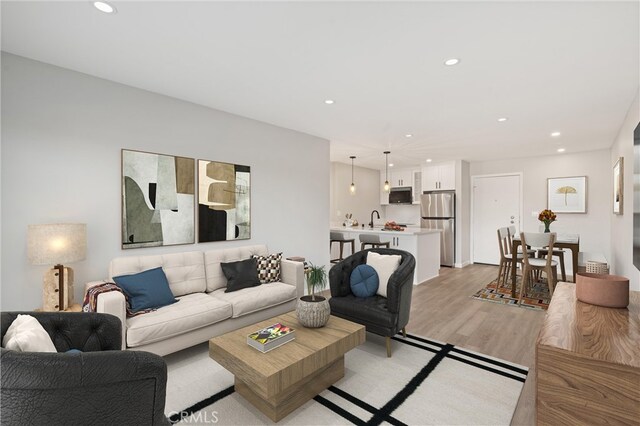 living room with sink and light hardwood / wood-style flooring