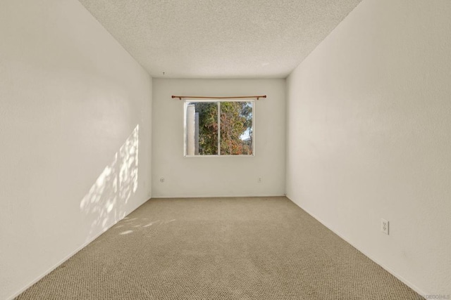 carpeted empty room featuring a textured ceiling