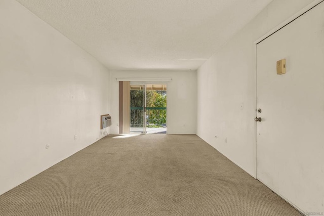 carpeted spare room with a textured ceiling and a wall mounted AC