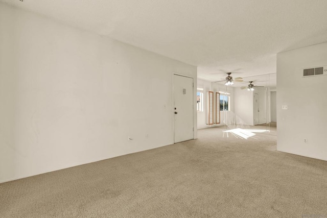 spare room with ceiling fan and light carpet