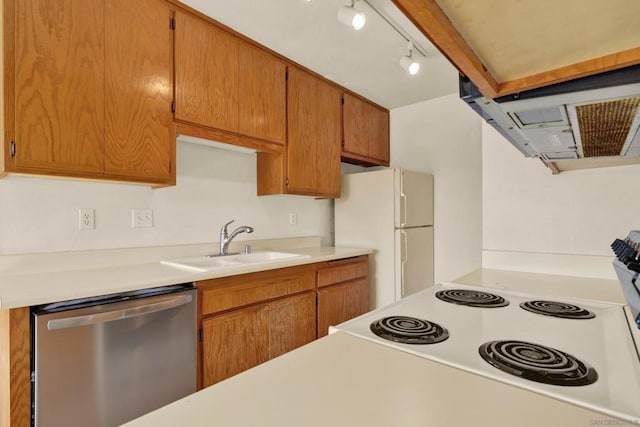 kitchen featuring white appliances, rail lighting, and sink