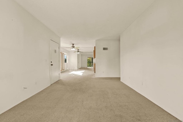 spare room with ceiling fan and light colored carpet