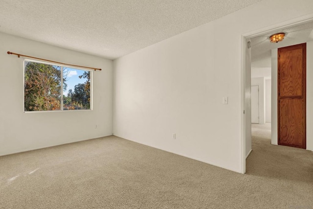 carpeted spare room with a textured ceiling