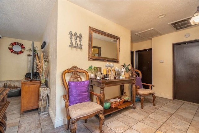 sitting room featuring light tile patterned floors and a textured ceiling