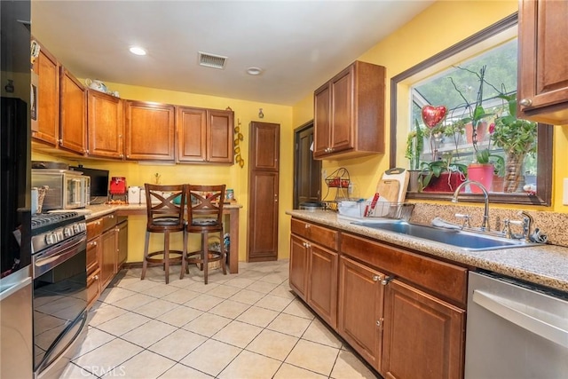 kitchen featuring sink, stainless steel appliances, and light tile patterned flooring