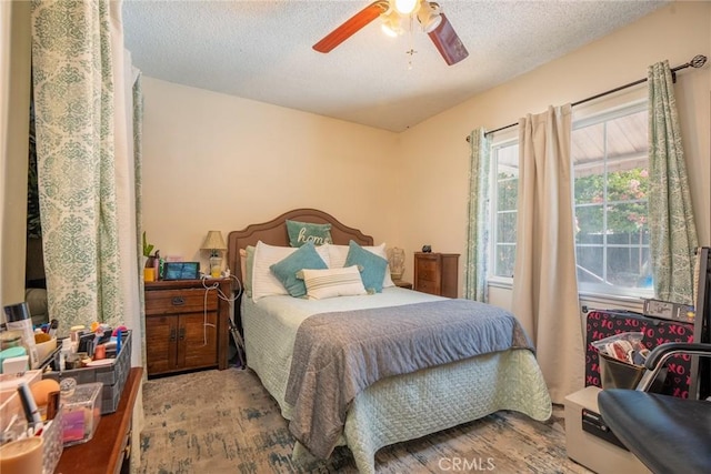 bedroom featuring ceiling fan and a textured ceiling