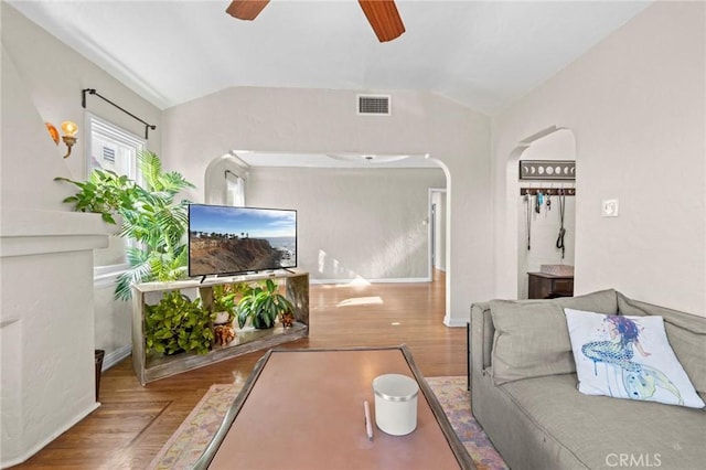 living room with ceiling fan, vaulted ceiling, and hardwood / wood-style flooring