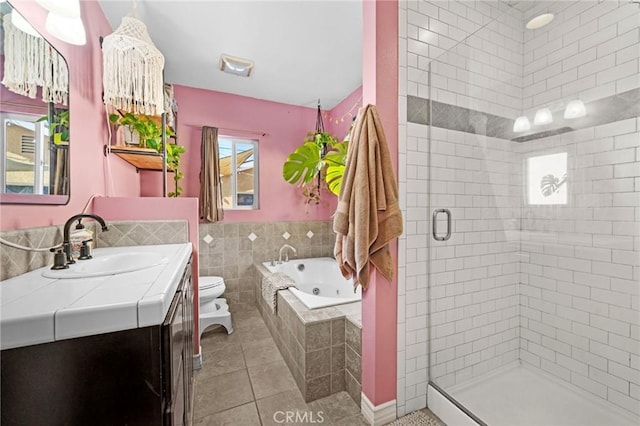 full bathroom featuring vanity, tile patterned flooring, separate shower and tub, toilet, and tile walls