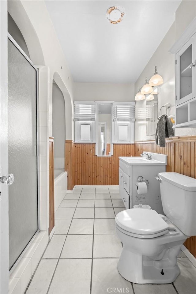 full bathroom with vanity, wood walls, tile patterned floors, separate shower and tub, and toilet