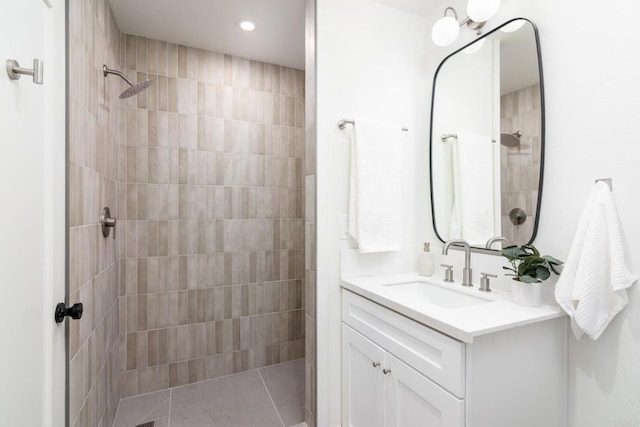 bathroom featuring a tile shower and vanity