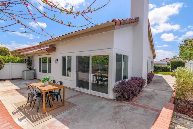 rear view of property with central air condition unit and a patio area