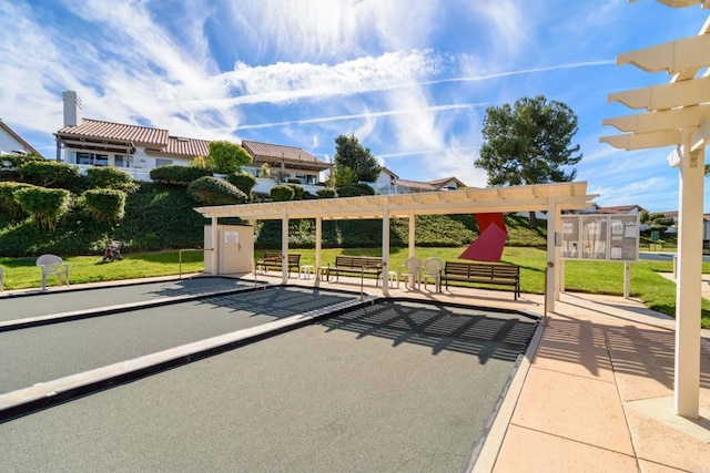 view of community with a pergola, a patio area, and a yard