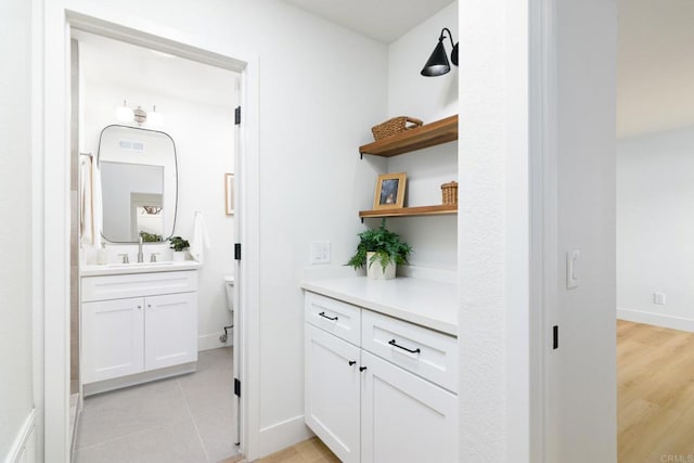 interior space featuring white cabinets, light tile patterned floors, and sink