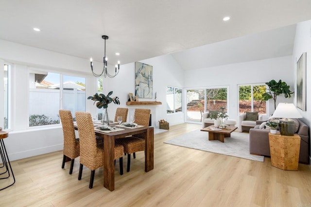 dining room featuring a chandelier, vaulted ceiling, and light hardwood / wood-style flooring