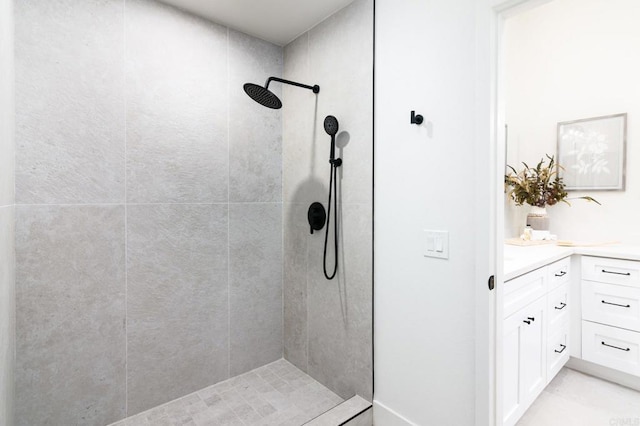 bathroom featuring a tile shower and vanity