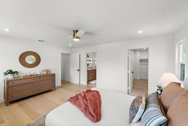 bedroom featuring a walk in closet, ceiling fan, light wood-type flooring, connected bathroom, and a closet