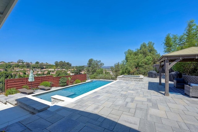 view of pool with a gazebo, area for grilling, a patio area, and an in ground hot tub