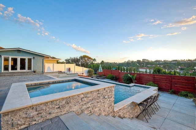 view of swimming pool featuring a bar and a patio