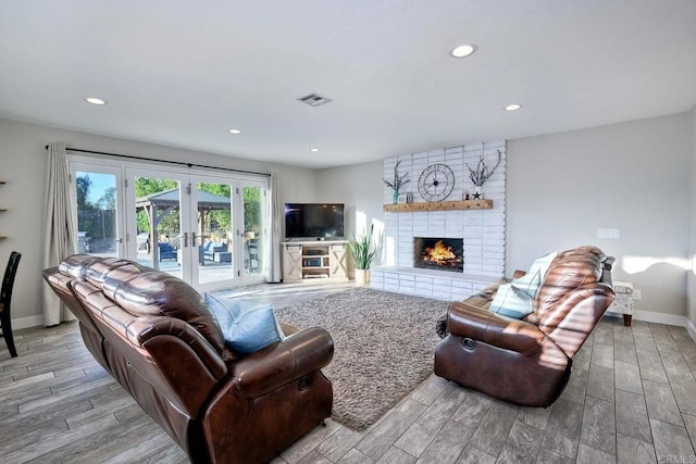 living room with french doors and a brick fireplace