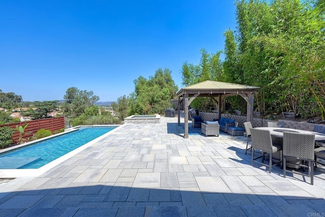 view of pool featuring an in ground hot tub, a gazebo, an outdoor hangout area, and a patio area