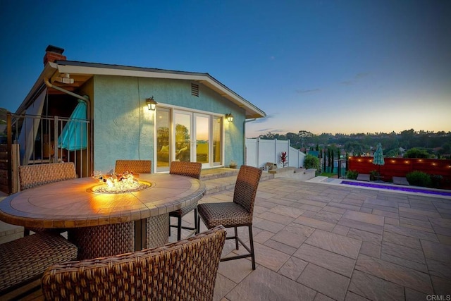 patio terrace at dusk featuring an outdoor fire pit