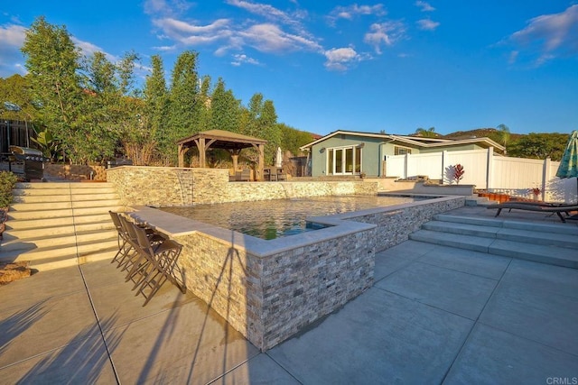 exterior space with an outbuilding, a gazebo, an outdoor bar, and a patio area