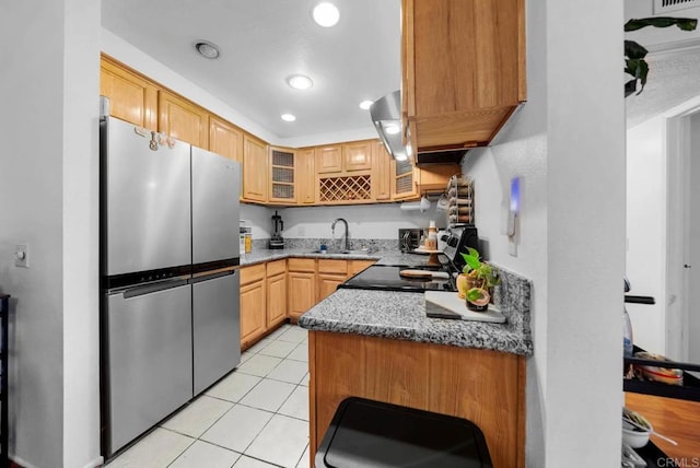 kitchen featuring stainless steel refrigerator, sink, light stone counters, light tile patterned floors, and range