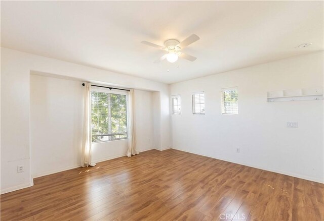 empty room with hardwood / wood-style floors and ceiling fan