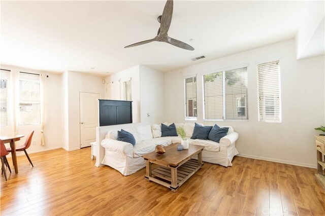 living room featuring ceiling fan, a healthy amount of sunlight, and light wood-type flooring