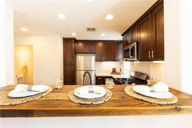 kitchen featuring appliances with stainless steel finishes and dark brown cabinets