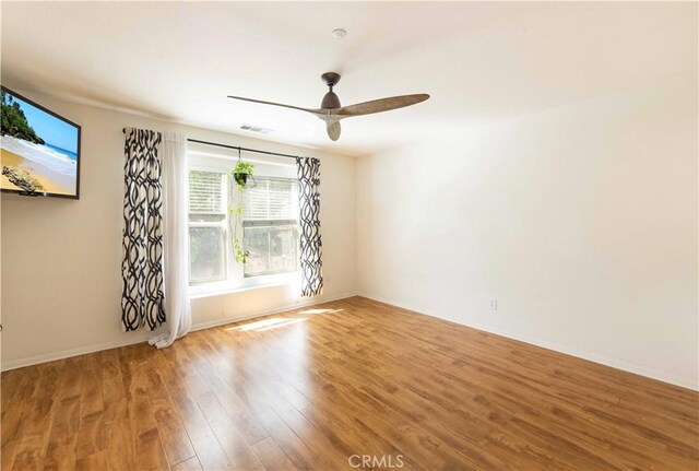 empty room with ceiling fan and hardwood / wood-style floors