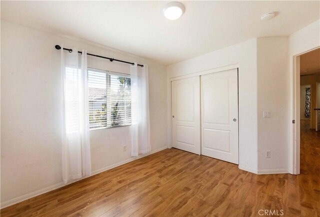 unfurnished bedroom featuring hardwood / wood-style flooring and a closet