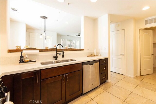 kitchen featuring stainless steel dishwasher, dark brown cabinetry, sink, light tile patterned floors, and decorative light fixtures