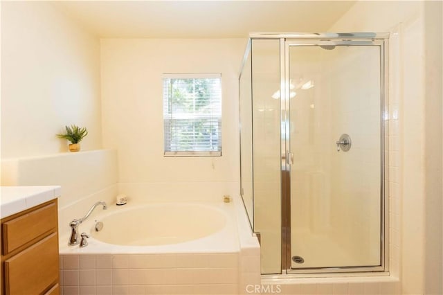 bathroom with vanity and shower with separate bathtub