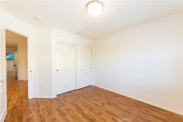 unfurnished bedroom featuring hardwood / wood-style floors and a closet