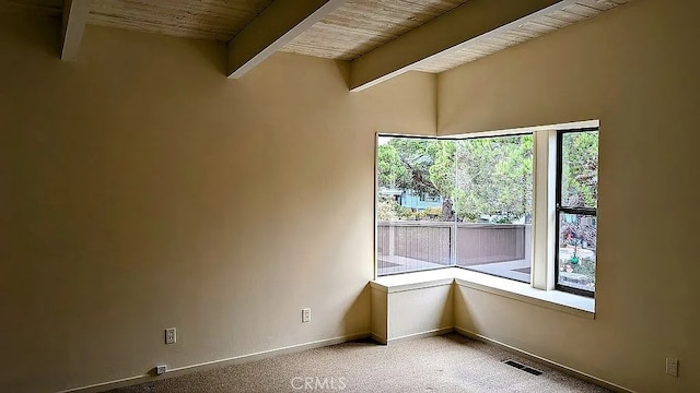 spare room featuring beam ceiling, wooden ceiling, and light carpet