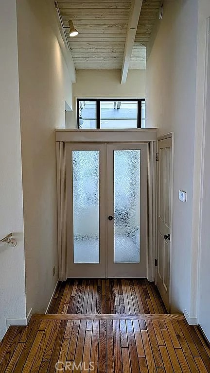 doorway to outside featuring beam ceiling, dark wood-type flooring, french doors, and wood ceiling