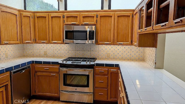 kitchen with backsplash, tile countertops, and appliances with stainless steel finishes